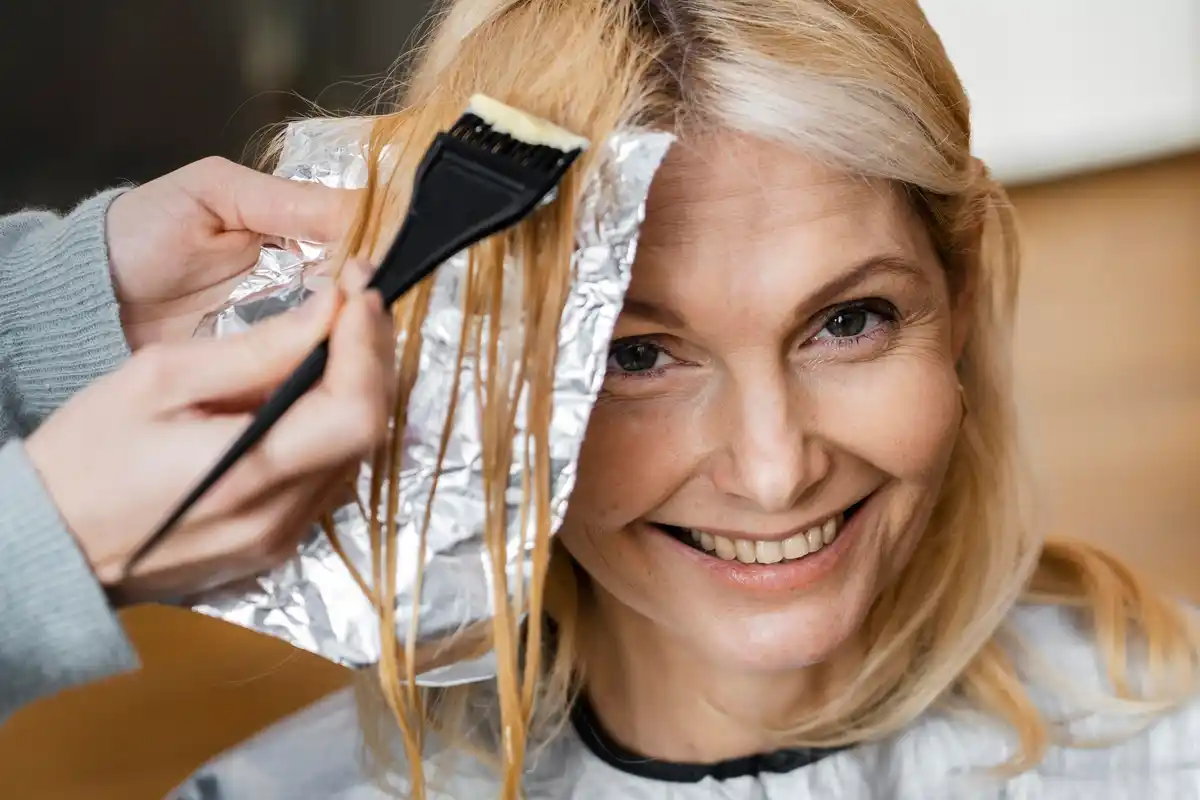 applying hair dye close-up with brush on roots