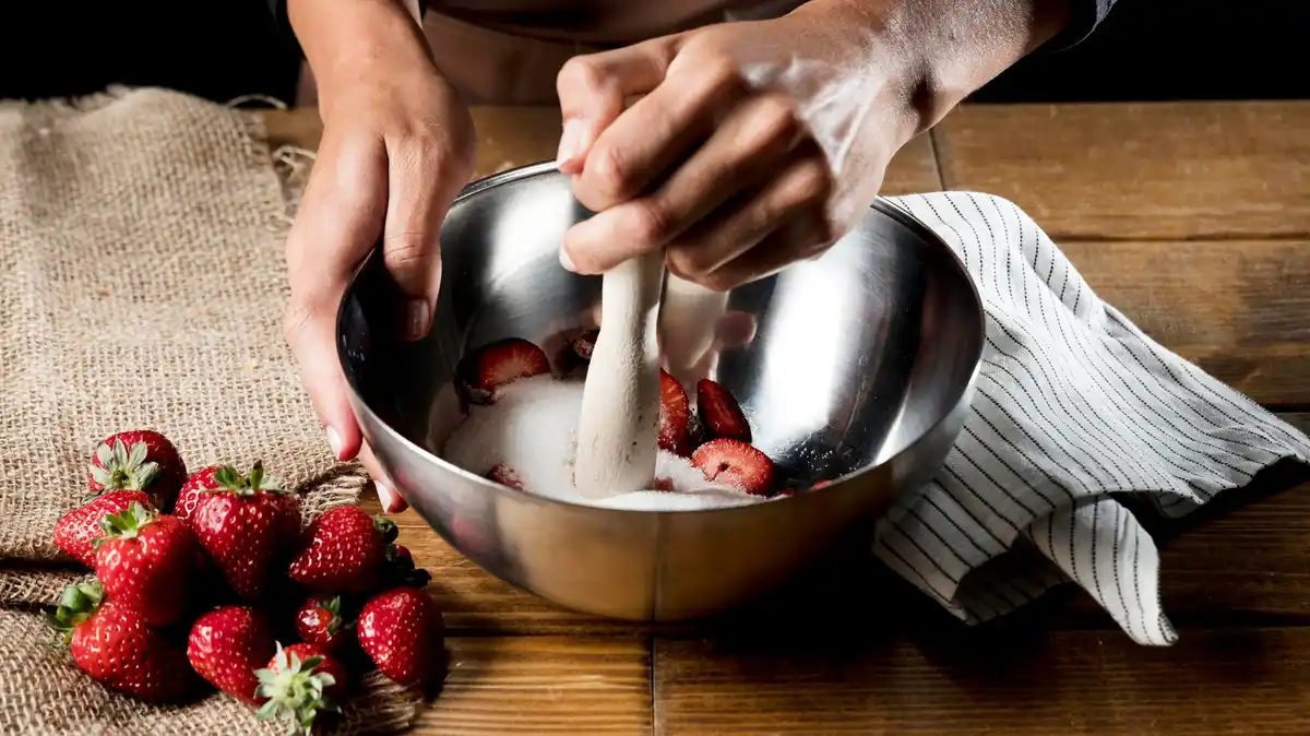 hand sprinkling cinnamon on fresh berries