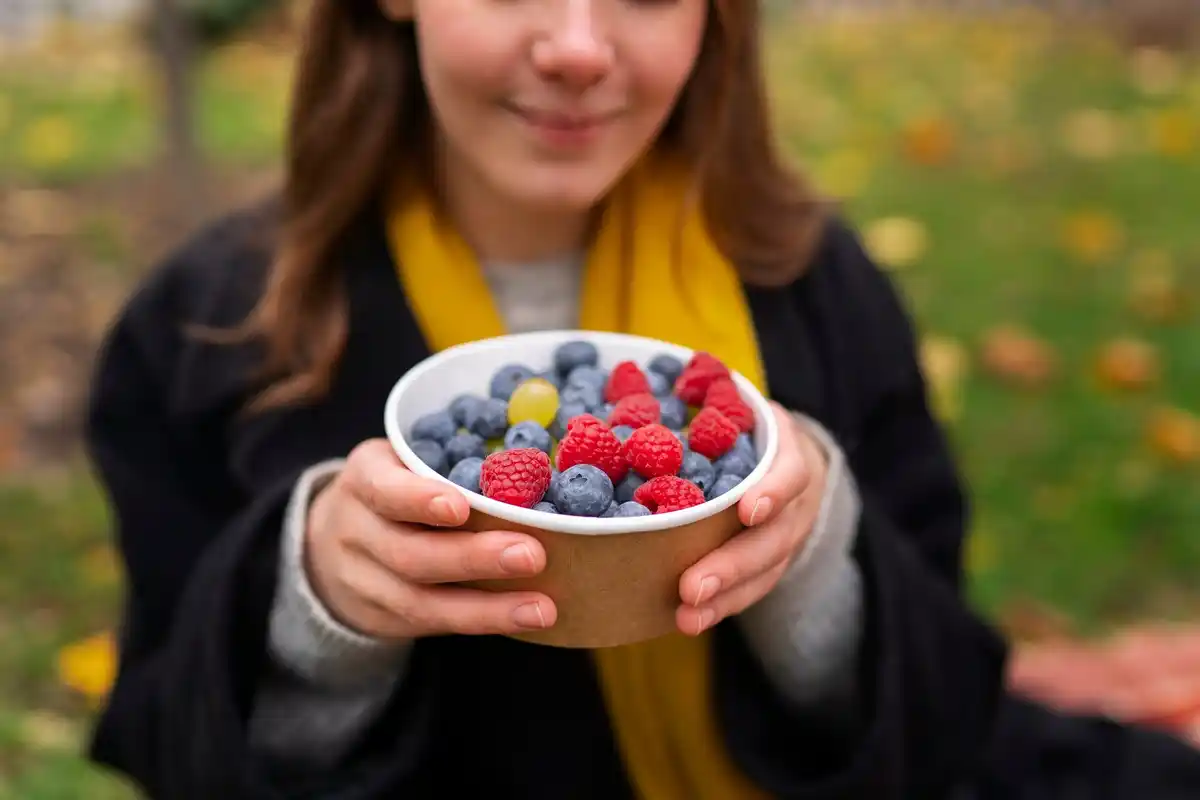 Harvesting fresh berry fruits from garden bush