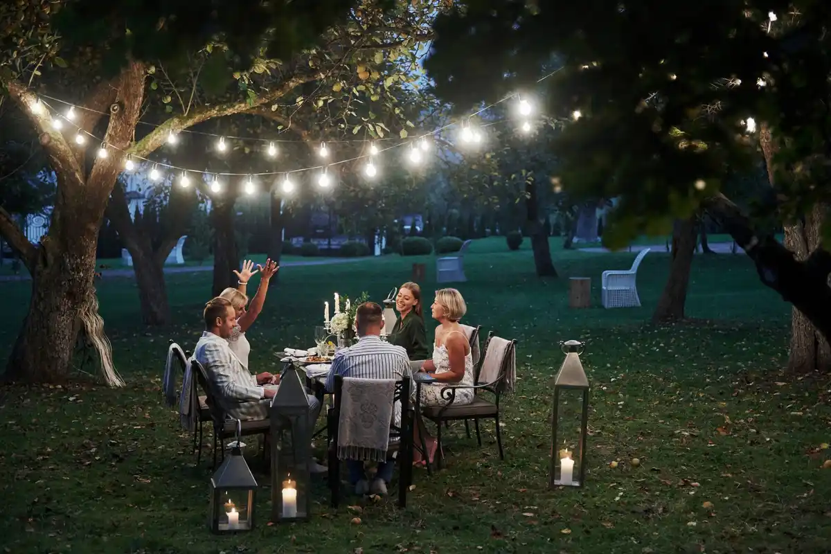 warm outdoor lighting with candles and string lights in garden evening